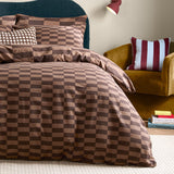 Bedroom scene with The Ultimate Checkerboard Cotton Blend Pillowcase Pair in Chocolate Truffle, styled on a bed with matching checkerboard duvet cover in brown tones.