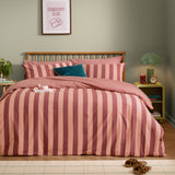 The Ultimate Stripe Reversible Duvet Cover Set in Raspberry Smoothie, wide pink and blush stripes on a bed with matching pillowcases in a bedroom setting.