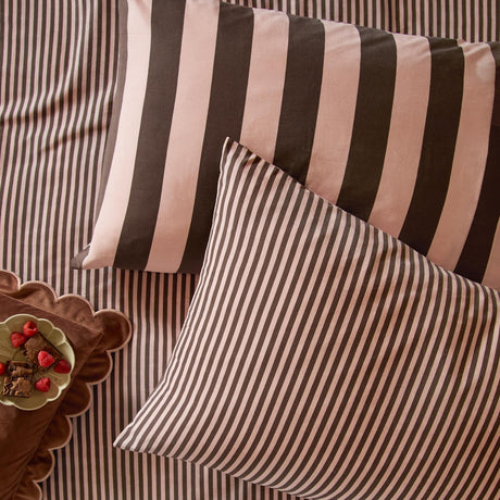 The Ultimate Stripe Cotton Blend Pillowcase Pair in Berry Brownie, shown on matching striped bedding with broad and narrow stripe designs in dusky pink and cocoa brown.