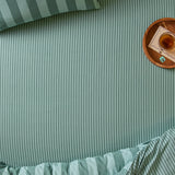 The Ultimate Stripe Cotton Blend Fitted Sheet in Peppermint on a bed with matching pillowcase, styled with a wooden tray, drink, and notepad.