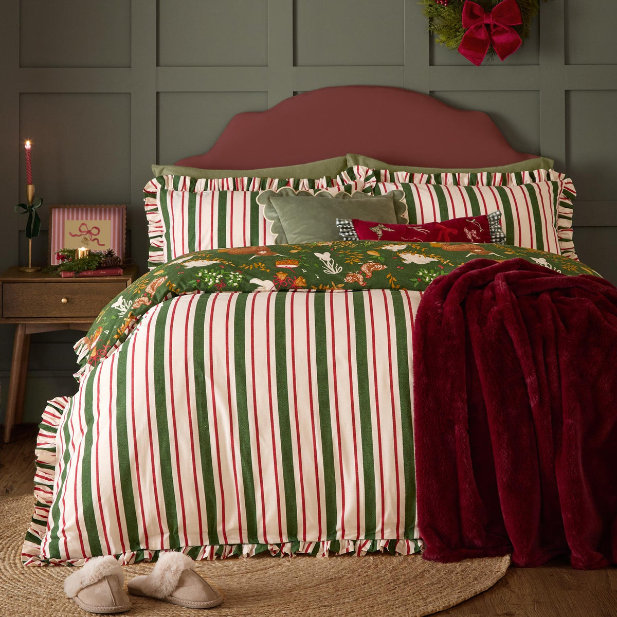 Twelve Days Frill Cotton Striped Duvet Cover Set in green, red and cream stripes with scalloped ruffle edges, styled on a bed with a green Christmas print reverse and burgundy throw.