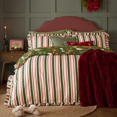 Twelve Days Frill Cotton Striped Duvet Cover Set in green, red and cream stripes with scalloped ruffle edges, styled on a bed with a green Christmas print reverse and burgundy throw.