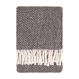 Tweedie Herringbone Polyester Throw in charcoal, folded flat with a two-tone grey chevron weave and white twisted fringe tassels, shown on a plain white background.
