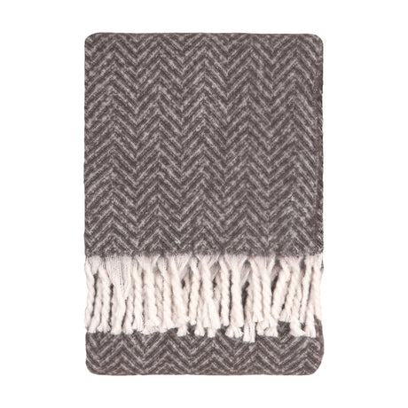 Tweedie Herringbone Polyester Throw in charcoal, folded flat with a two-tone grey chevron weave and white twisted fringe tassels, shown on a plain white background.
