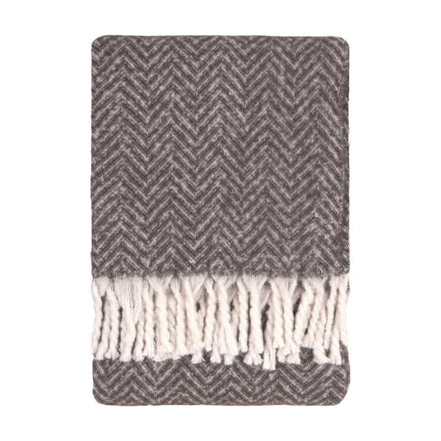 Tweedie Herringbone Polyester Throw in charcoal, folded flat with a two-tone grey chevron weave and white twisted fringe tassels, shown on a plain white background.