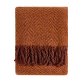 Tweedie Herringbone Polyester Throw in cinnamon, folded flat with a woven herringbone pattern and brushed fringe on each end, shown on a plain white background.