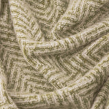Close-up of the Tweedie Herringbone Polyester Throw in green, showing the woven zigzag pattern in green and cream fabric.