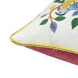 Corner detail of the 12 Days of Xmas Embroidered Velvet Cushion, showing a cream front with embroidered bird and leaf design, gold piped edge, and pink velvet reverse.