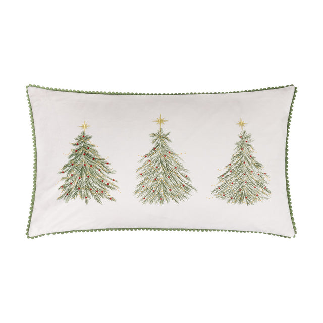 Rectangular cream velvet cushion embroidered with three green Christmas trees with red berries and gold stars, edged in green pompom trim, shown on a white background.
