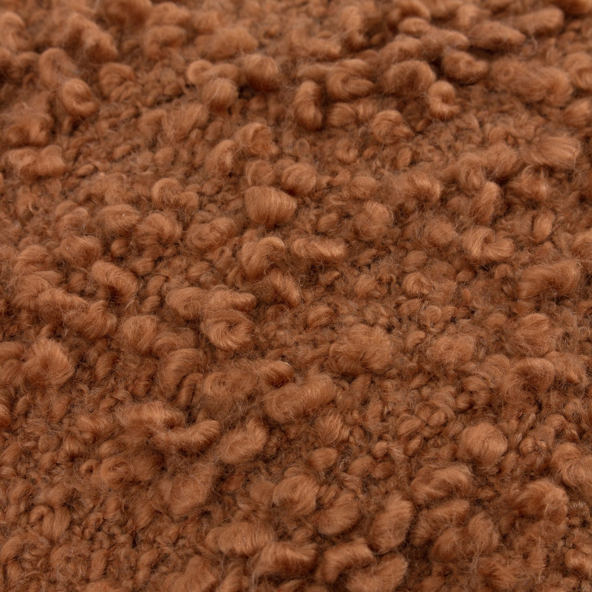 Close-up of the Ulsmere Wool Cotton Cushion in Ginger, showing dense, curly boucle-textured yarn in a warm ginger-brown finish.