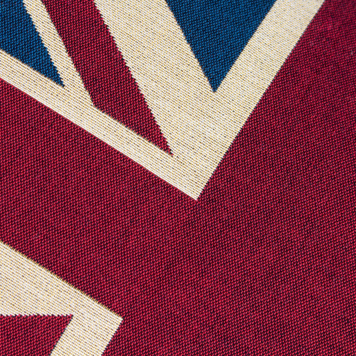 Close-up of Union Jack Jacquard Cotton Cushion in red, cream and navy, showing the woven cotton texture of the flag's diagonal and cross design.