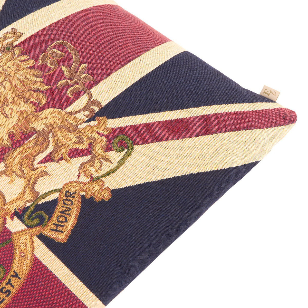 Close-up of the Union Jack Jacquard Cotton Cushion corner, showing woven red, navy and cream stripes with a gold heraldic lion crest and "Honor" scroll detail on a white background.
