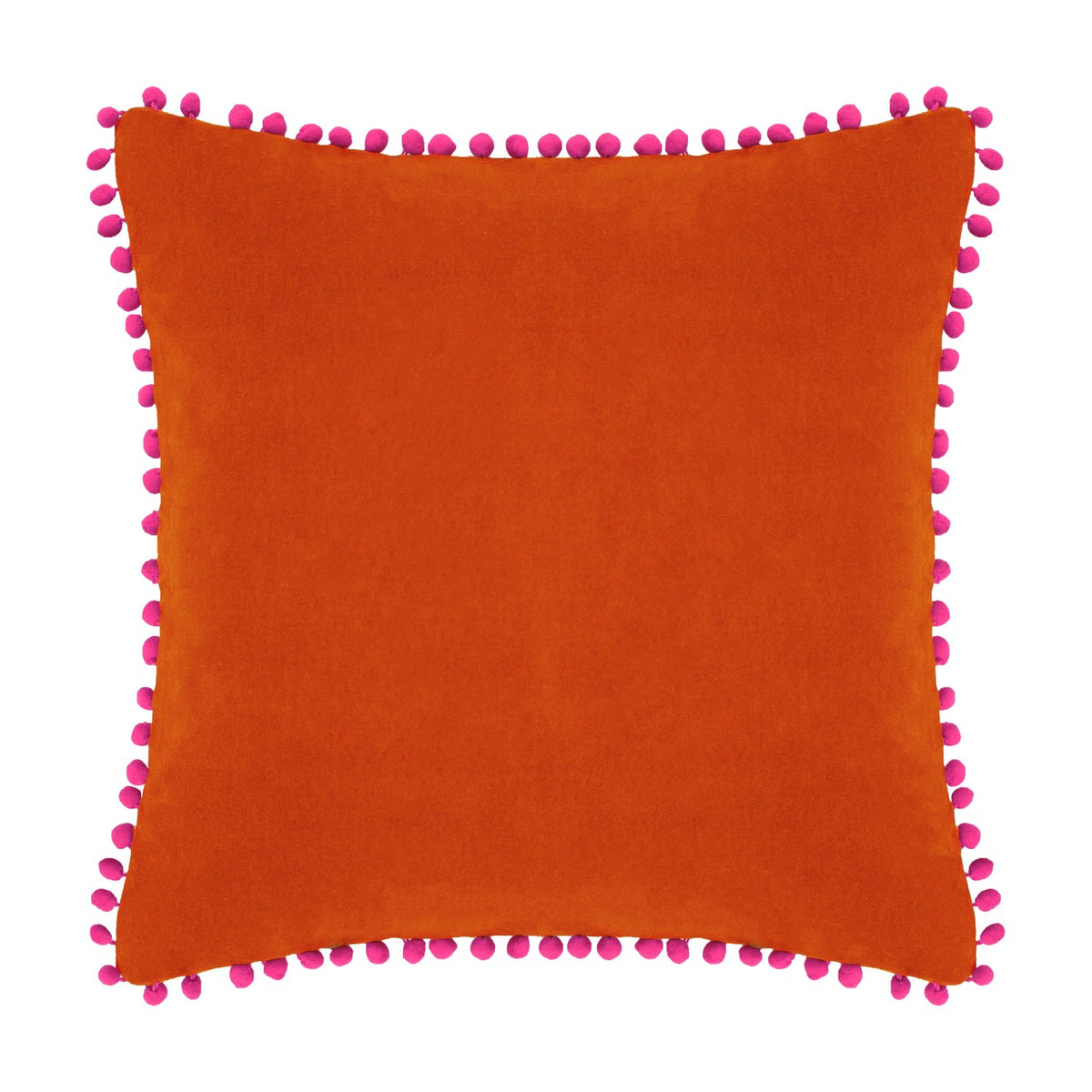 Square velvet cotton cushion in burnt orange with fuchsia pompom trim edging, shown on a plain white background.