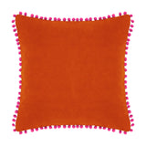 Square velvet cotton cushion in burnt orange with fuchsia pompom trim edging, shown on a plain white background.