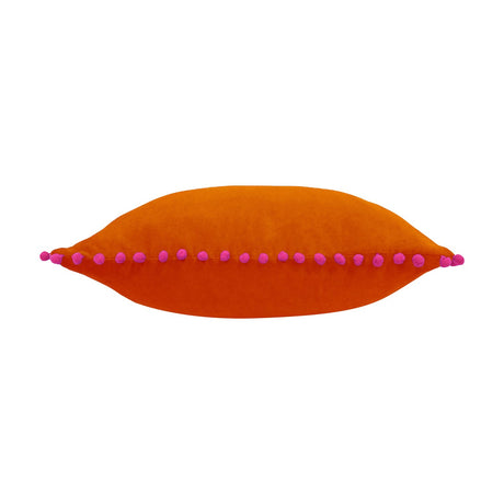 Velvet Pompom Plain Cotton Cushion in burnt orange with fuchsia pompom trim along the edges, shown on a plain white background.