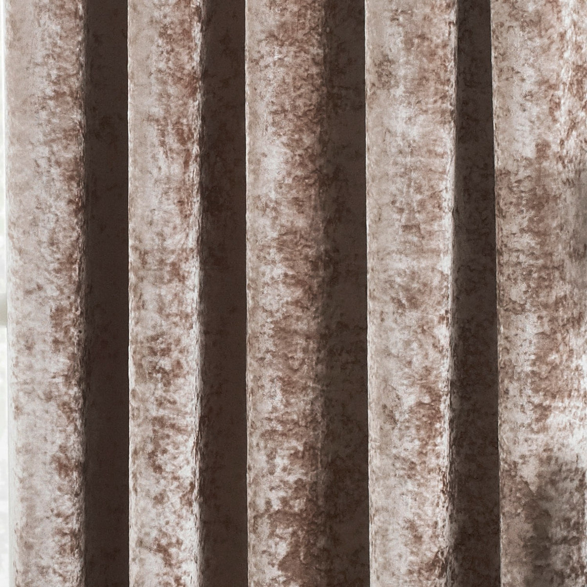 Close-up of Verona Velvet Fully Lined Eyelet Curtains in Oyster, showing deep folds and the mottled, light-catching sheen of crushed velvet fabric.