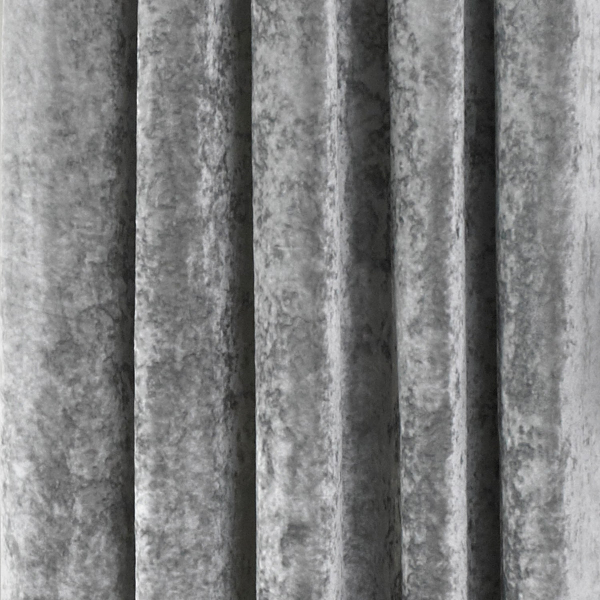 Close-up of Verona crushed velvet eyelet curtain in silver, showing soft folds and a mottled, light-catching texture.