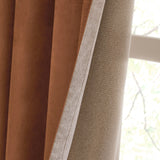 Close-up of Verso Polyester Blackout Eyelet Curtains in cinnamon, showing the velvety brown face and pale beige lining folded back near a window.