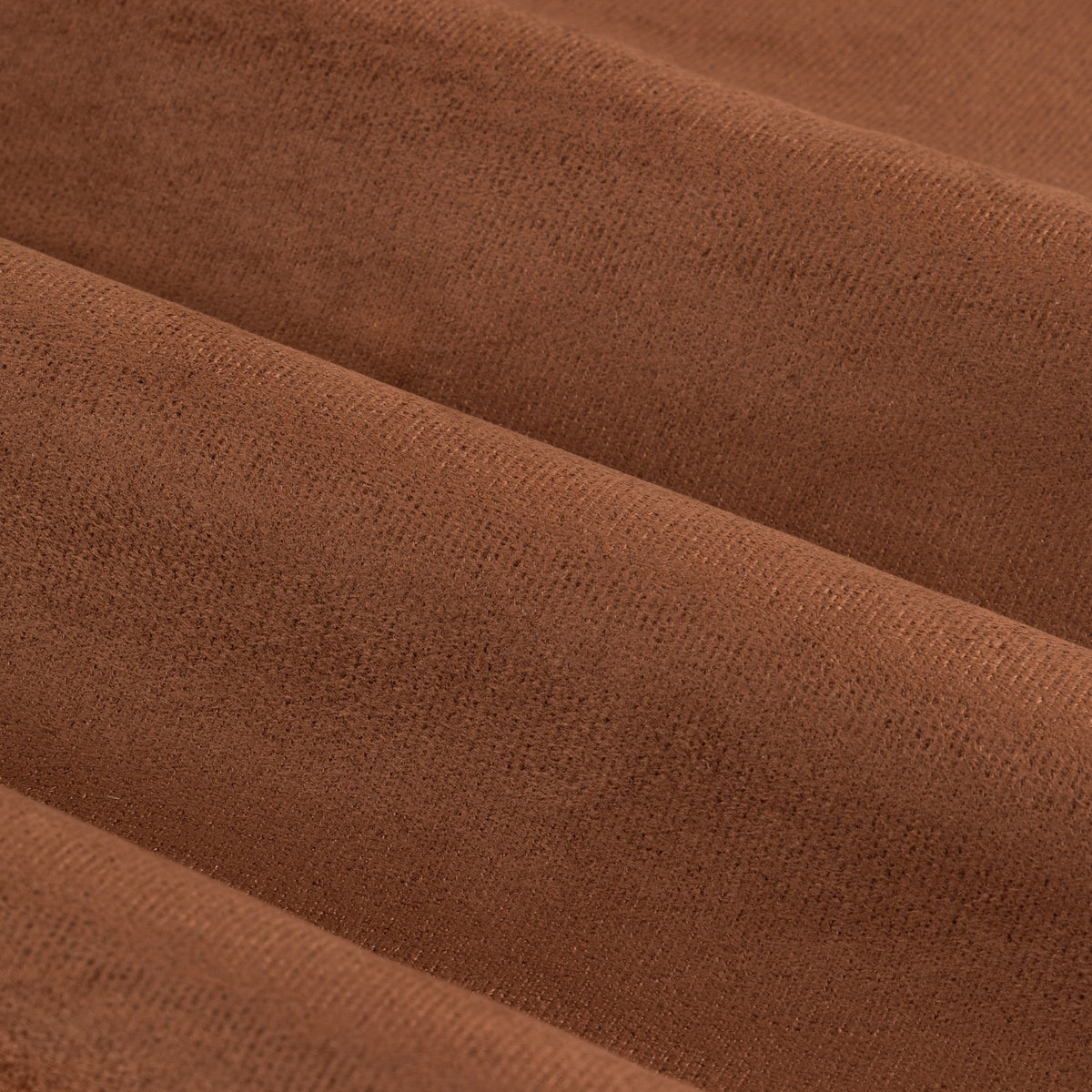 Close-up of Verso Blackout Eyelet Curtains in cinnamon, showing soft velvety polyester fabric folds in a deep russet brown.