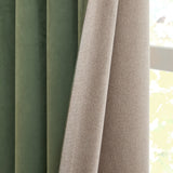 Verso Plain Reversible Eyelet Curtains in Green, close-up showing folded panels with green suede-effect fabric on one side and beige woven fabric on the reverse, beside a window.
