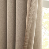 Close-up of Verso Reversible Eyelet Curtains in mocha, showing folded panels with a suede face on one side and a flatter woven reverse, hung by a window.