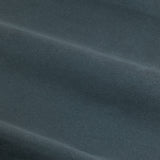 Close-up of Verso reversible eyelet curtain fabric in petrol blue, showing a soft suede-look woven surface with visible fold lines.