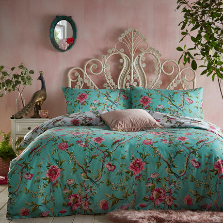 Vintage Chinoiserie Printed Floral Duvet Cover Set in jade green with pink blooms and bird motifs, shown on a bed with matching pillowcases in a pink-toned bedroom.