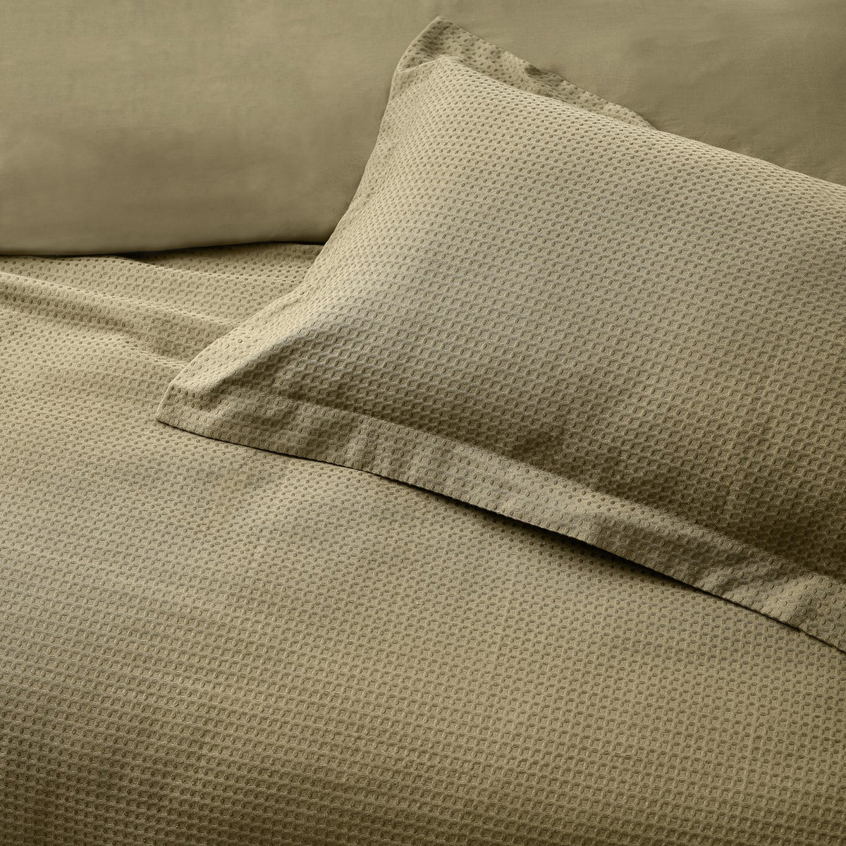 Waffle Cotton Plain Duvet Cover Set in olive, showing the textured cotton weave on the duvet and matching pillowcase with a plain flanged edge on the bed.