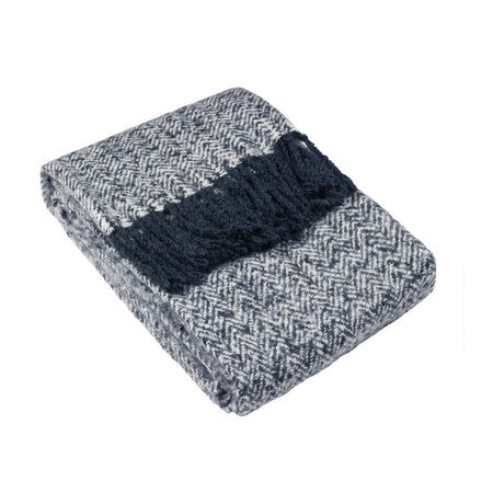 Weaver Geometric Wool Throw in navy, folded with a herringbone chevron weave and a solid navy fringed band, shown on a plain white background.
