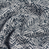 Close-up of the Weaver Geometric Wool Throw in navy, showing a herringbone chevron weave in deep blue with pale flecks, softly draped to reveal texture.