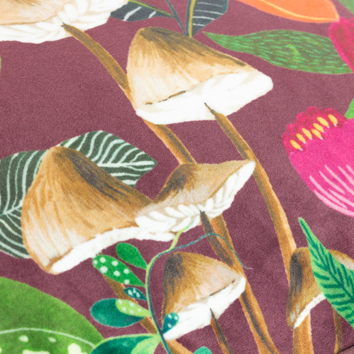 Close-up of the Wild Garden Floral Velvet Cushion in multicolour, showing printed tan-capped mushrooms and pink, orange and green florals on a wine-red velvet ground.