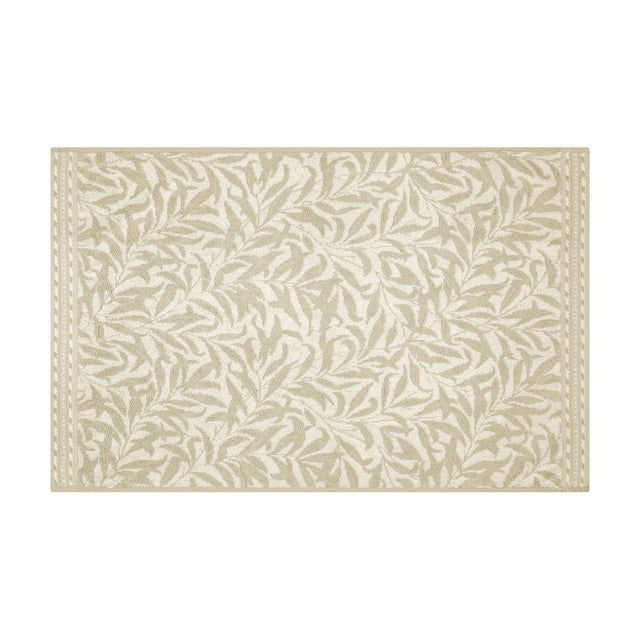 Willow Boughs cotton bath mat in natural, featuring a sandy beige trailing leaf pattern with a dotted border on off-white ground, shown on a plain white background.