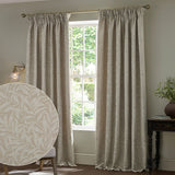 Willow Boughs jacquard linen pencil pleat curtains in beige with a woven leaf pattern, shown pleated at a window in a living room, with a fabric swatch inset.