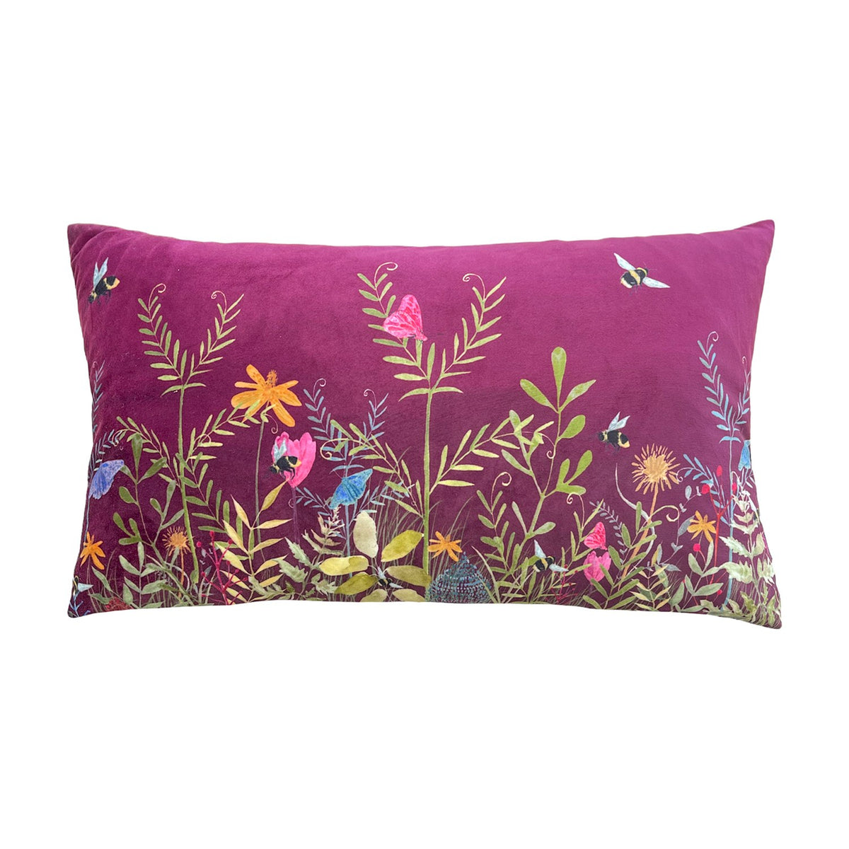 Willow Floral Velvet Cushion in deep fuchsia, rectangular bolster shape with printed meadow design of bees, butterflies and wildflowers in orange, pink and blue, shown on a white background.