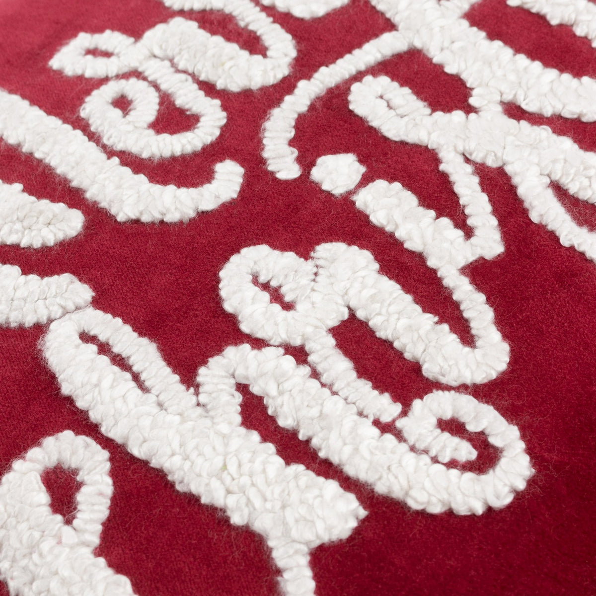 Close-up of the Winter Merry Christmas Velvet Cotton Cushion in red, showing raised white boucle-tufted script lettering on deep red cotton velvet.