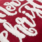 Close-up of the Winter Merry Christmas Velvet Cotton Cushion in red, showing raised white boucle-tufted script lettering on deep red cotton velvet.