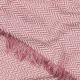 Wisley Herringbone Polyester Throw in heather/pink, close-up of the zigzag weave with a tasselled fringe edge.