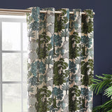 Woodlands Jacquard Fully Lined Eyelet Curtains in Green, showing a woven woodland scene of trees in green, teal and grey on cream fabric, hung on a metal pole by a window.