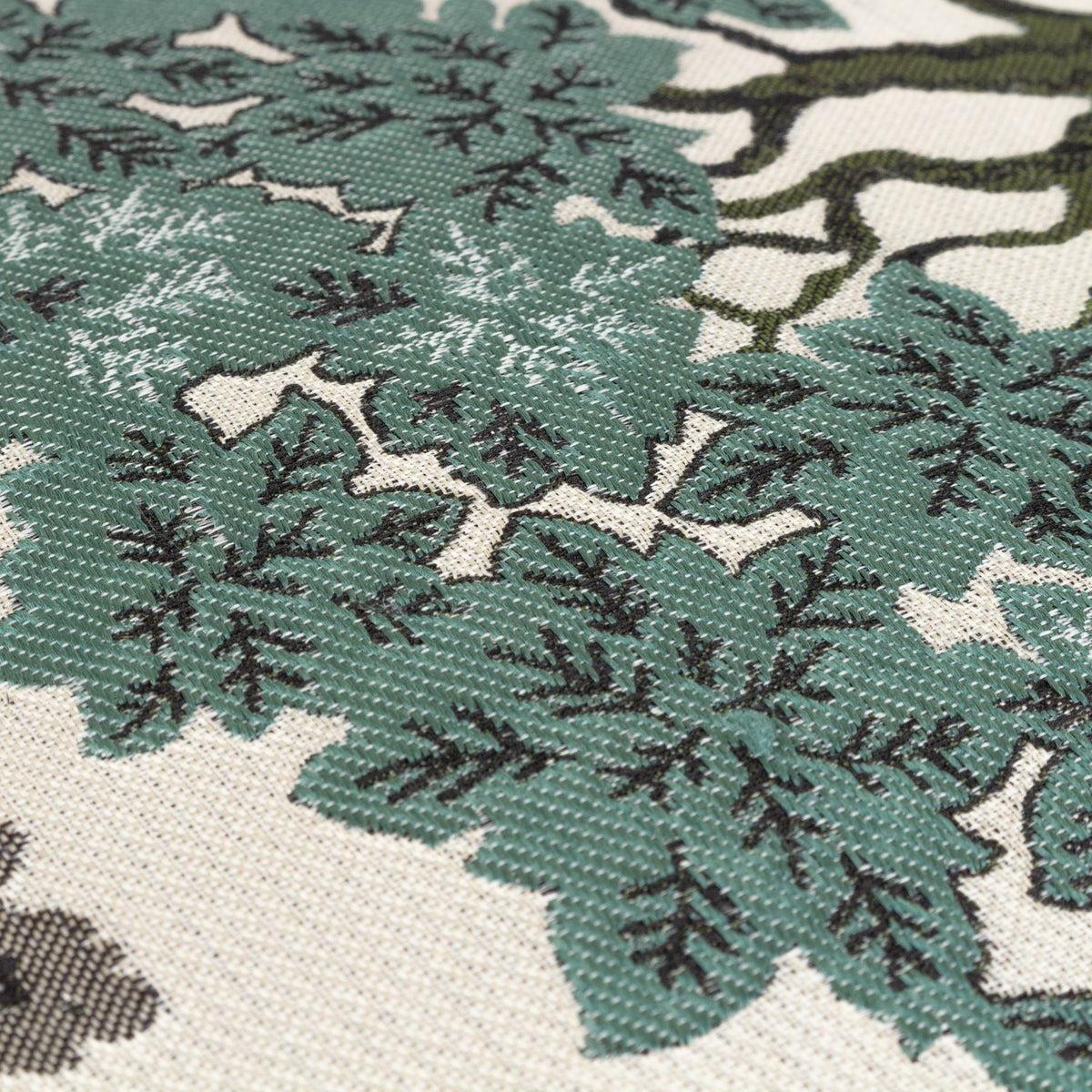 Close-up of the Woodlands Eyelet Velvet Cushion in green, showing the woven jacquard tree canopy pattern in green, sage and cream with textured leaf and branch detail.