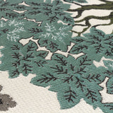 Close-up of the Woodlands Eyelet Velvet Cushion in green, showing the woven jacquard tree canopy pattern in green, sage and cream with textured leaf and branch detail.