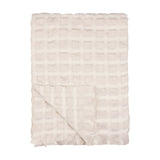 Walton Waffle Check Linen Throw in cream, folded to show its waffle-weave grid pattern and fringed edge, on a plain white background.