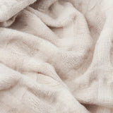 Close-up of the Walton Waffle Check Linen Throw in cream, showing its raised waffle-weave texture in soft folds.