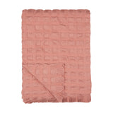 Walton Waffle Check Polyester Throw in rose pink, folded to show its raised waffle grid texture and fringed edge, on a plain white background.