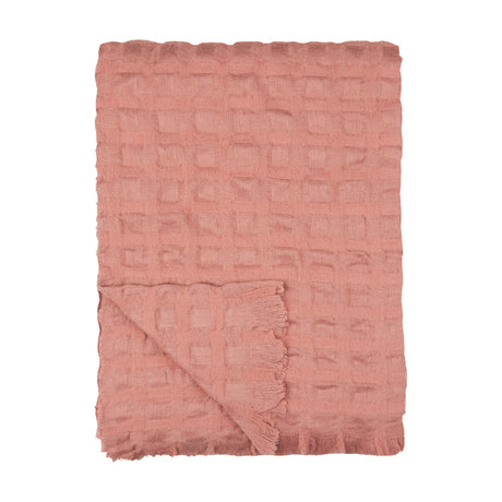 Walton Waffle Check Polyester Throw in rose pink, folded to show its raised waffle grid texture and fringed edge, on a plain white background.