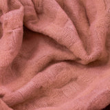 Close-up of the Walton Waffle Check Polyester Throw in rose pink, showing the textured waffle grid weave draped in soft folds.