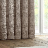 Winter Woods Chenille Lined Eyelet Curtains in taupe, showing a woven woodland animal and tree pattern in soft folds beside a bright window.