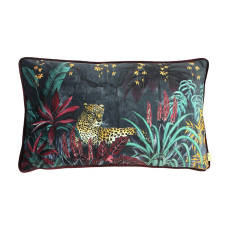 Zinara rectangular velvet bolster cushion in black, printed with a hand-painted jungle scene of a leopard among banana leaves and red aloes, wine-red velvet reverse, shown on a white background.