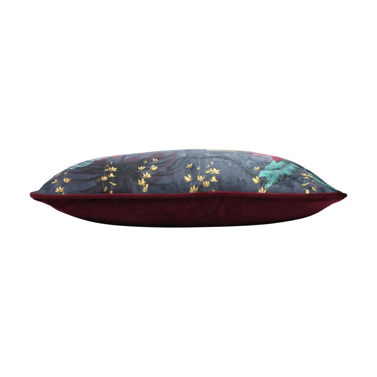 Side view of the Zinara rectangular bolster cushion, showing black velvet front with jungle foliage print piped against a plain wine-red velvet reverse, on a white background.