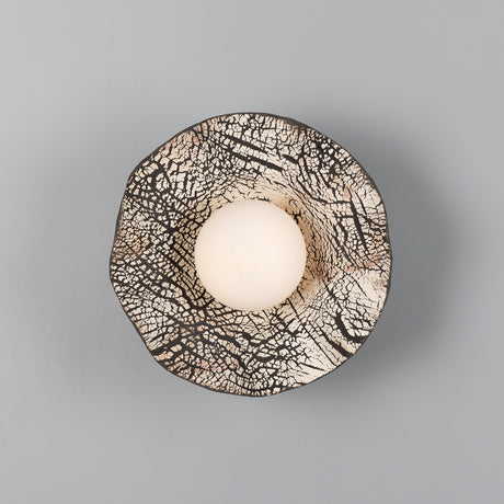 Rivale Ceramic Globe Wall Light in Black Clay, a wavy-rimmed shade with crackled dark pattern surrounding a central opal glass globe, shown on a plain grey background.