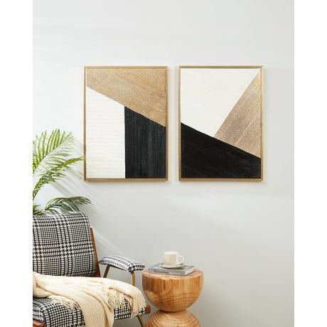Roberval Wall Art Set of 2 in black, white and gold, slim gold-framed abstract panels with ridged texture, shown hung above an armchair and wooden side table.